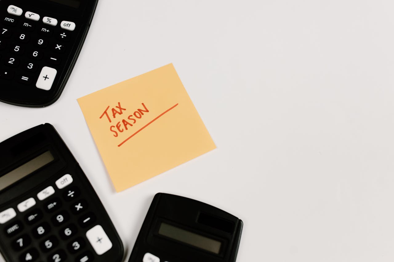 Calculators and sticky note labeled Tax Season on white background, ideal for financial themes.